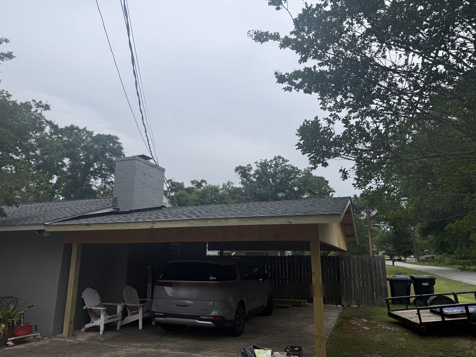 Attached carport with a shingle roof built off the side of a brick home in Columbus, GA
