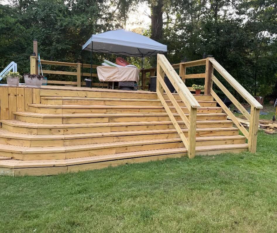Pressure-treated wood deck with wide wraparound steps and railings